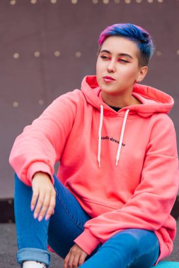 Pembe kapüşonlu kısa saçlı ve burunlu genç kız.