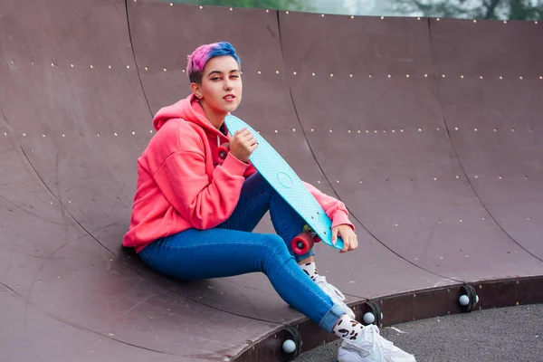 Wanita Muda Bergaya Dengan Rambut Pendek Berwarna Duduk Dengan Skateboard — Stok Foto