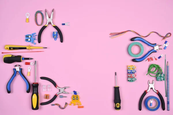 Set of electrical tools on pink background top view