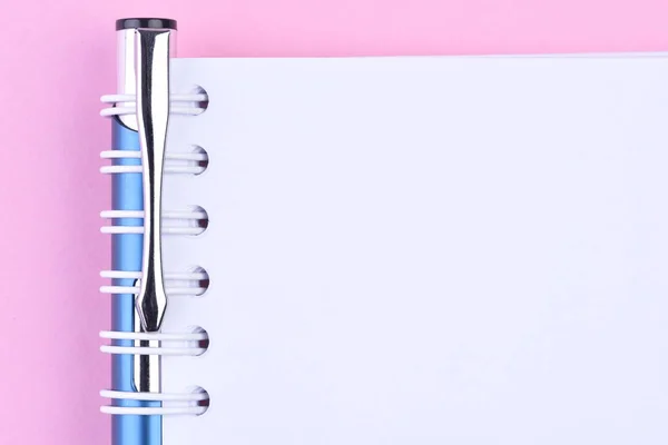 ピンクの背景のペンの白紙のメモ紙の本のトップ ビュー — ストック写真