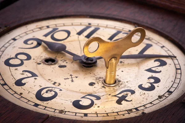 Old antique clock with key winder close-up