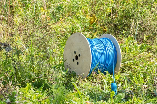 Cable drum with network cord on green meadow field