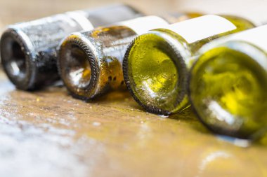 Islak masada duran boş şarap şişelerini kapatın.