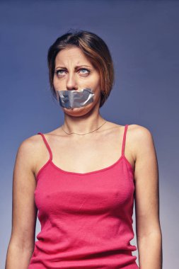 kadın ağzını bantla yapıştırılmış. Aşağılanma ve kadınların ayrımcılık kavramı