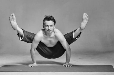 Genç adam bir stüdyoda yoga yapan