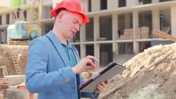 Mladý architekt pracuje na tabletu poblíž staveniště — Stock video