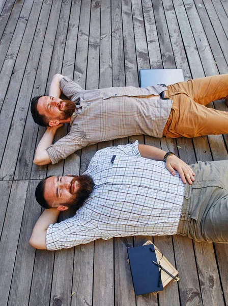 Zwei Geschäftsleute in einer Arbeitspause. er schaut entspannt in den Himmel — Stockfoto