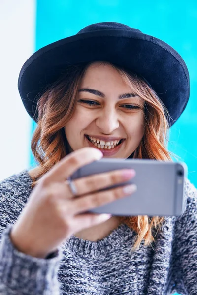 Uma jovem menina bonita se comunicando através de um smartphone — Fotografia de Stock