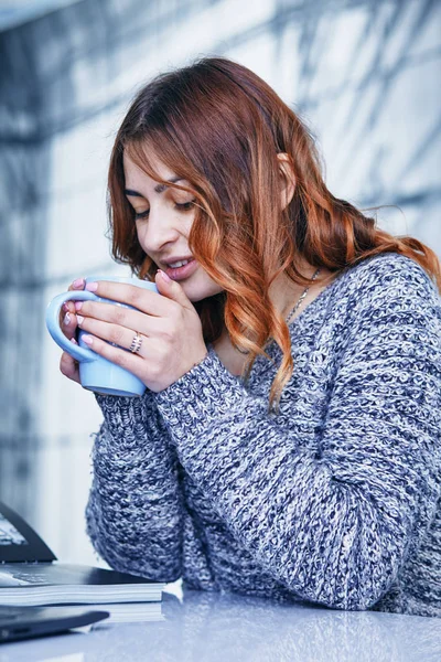 Молодая женщина пьет кофе в кафе — стоковое фото