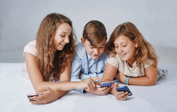 Kinder konzentrieren sich auf das Spielen von Smartphones. — Stockfoto