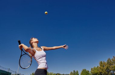 güzel güneşli bir günde sahada Tenis oynayan kız