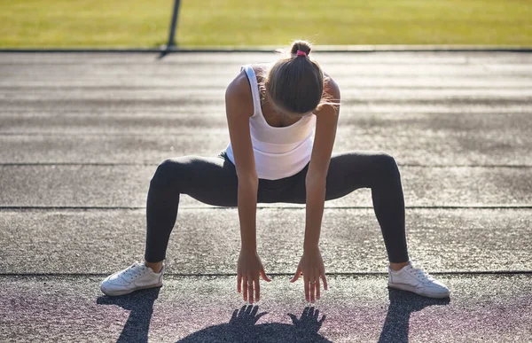 Corredor jovem apto mulher streching antes de exercícios ao ar livre. Strech feminino atlético após o treino fora. Esporte e conceito de pessoas. — Fotografia de Stock