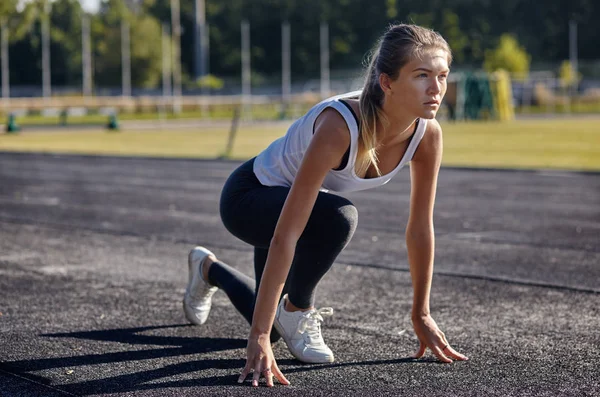 A young woman runner getting ready for a run on track — 图库照片