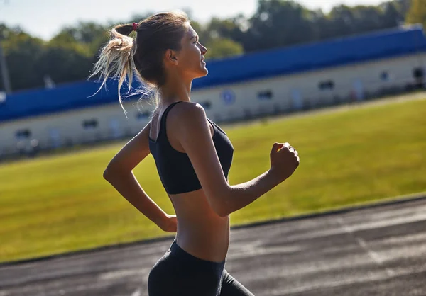 Ładna kobieta jogging w parku w świetle wschodu słońca — Zdjęcie stockowe