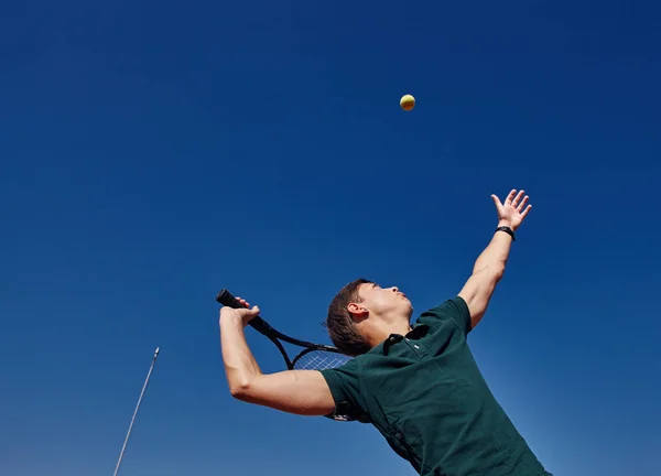 Ein Mann spielt an einem schönen sonnigen Tag Tennis auf dem Platz — Stockfoto