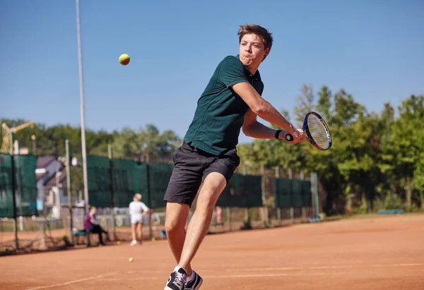 Человек, играющий в теннис на корте в прекрасный солнечный день — стоковое фото
