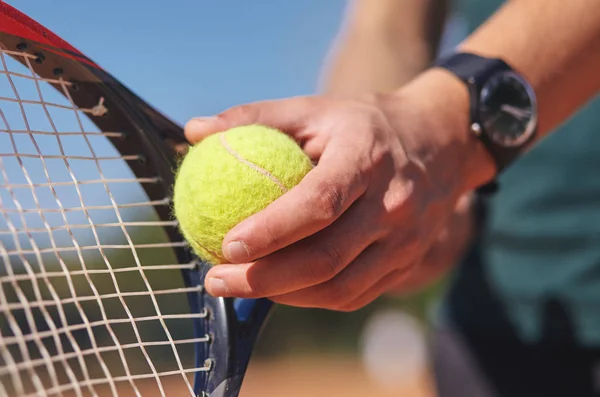 a Tennis player holding racket and ball in hands