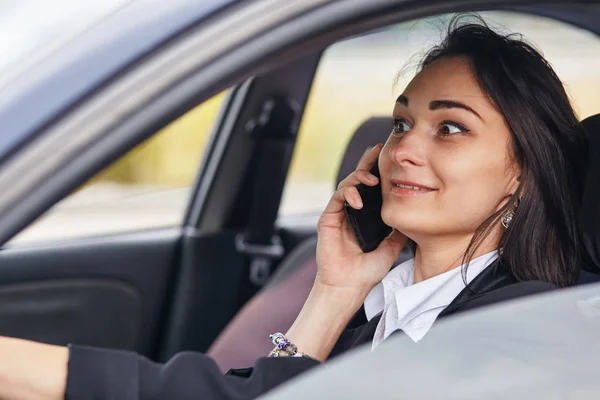 Une conductrice utilisant son téléphone portable pendant qu'elle conduisait une voiture — Photo