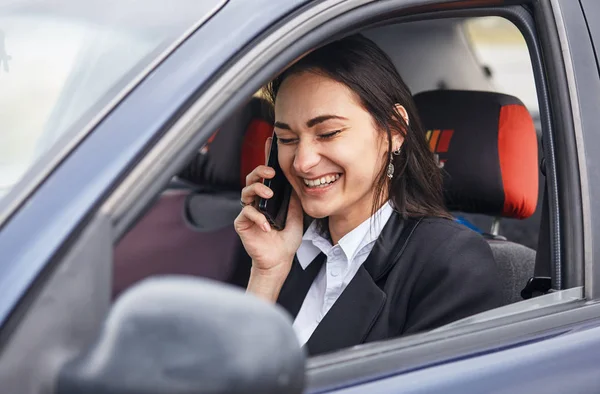 Une conductrice utilisant son téléphone portable pendant qu'elle conduisait une voiture — Photo