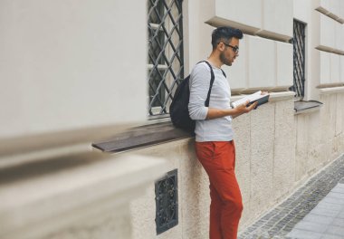 Genç adam kampüs bir kitap okuma