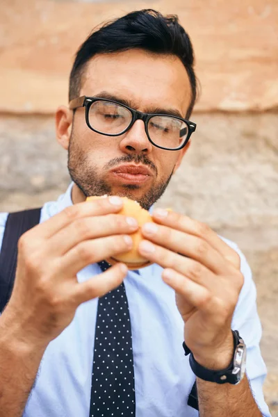 Fiatal üzletember, eszik egy hamburgert — Stock Fotó