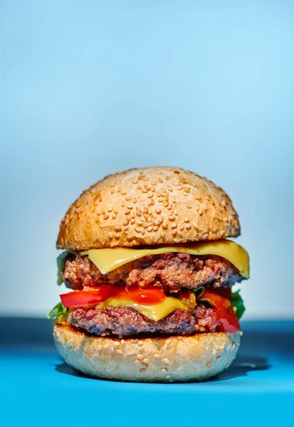 Hamburger con manzo, formaggio e verdure su sfondo blu — Foto Stock