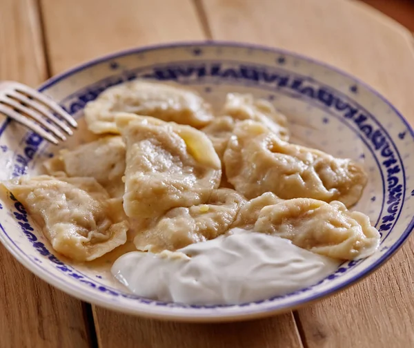 Delicious dumplings with sour cream — Stock Photo, Image