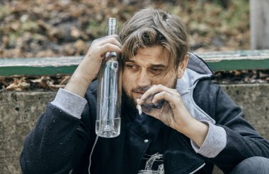 Bir bardak votka tutan adam kapatın. Sarhoş gençler. (alkolizm, ağrı, yazık, umutsuzluk, bağımlılık kavramı toplumsal sorun)