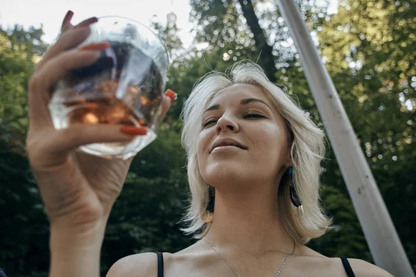 Mujer joven con bebida alcohólica que se ve muy triste y deprimida. Jóvenes borrachos (alcoholismo, dolor, lástima, desesperanza, problema social del concepto de dependencia) — Foto de Stock