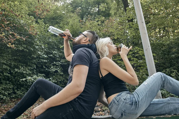 Conceito de dependência alcoólica. Deprimido e sem esperança casal sentado depois de usar álcool bêbado na rua — Fotografia de Stock