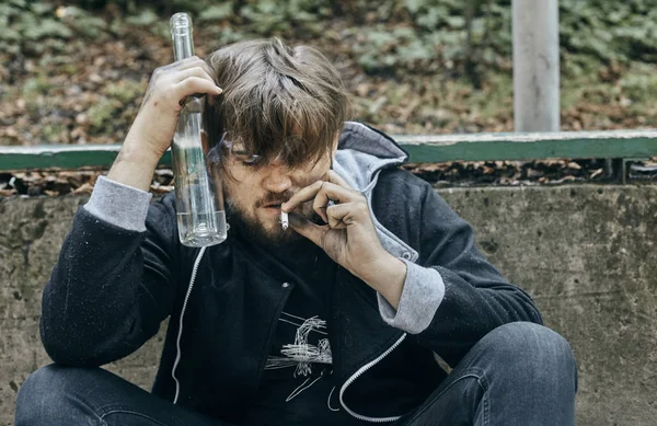 Bir bardak votka tutan adam kapatın. Sarhoş gençler. (alkolizm, ağrı, yazık, umutsuzluk, bağımlılık kavramı toplumsal sorun)