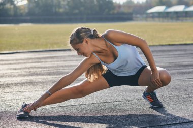 Genç bayan esniyor ve koşmaya hazırlanıyor..