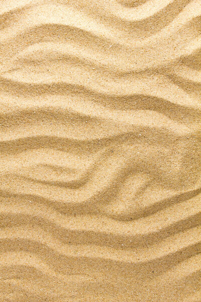 Closeup of sand pattern of a beach in the summer day. Nature background.