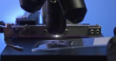 Yakın çekim bilimsel laboratuvar mikroskobu. Bilimadamı laboratuvarda test örneklerini inceliyor. Video tıp, bilim veya eğitim sektöründe kullanılabilir.