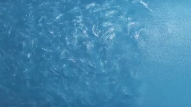 Peinture argentée sur fond abstrait d'eau. Tournage sur fond bleu. Mouvement lent .