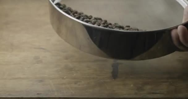 烤制的香喷喷的咖啡豆放在木制桌子上的筛子里冷却 慢动作 — 图库视频影像