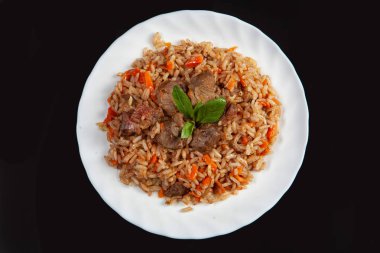 Siyah bir stüdyonun arka planında Asya yemek pilavı olan bir tabak.