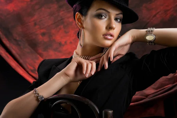 年轻漂亮的女人在黑色的衣服上的红色和黑色的工作室背景 — 图库照片