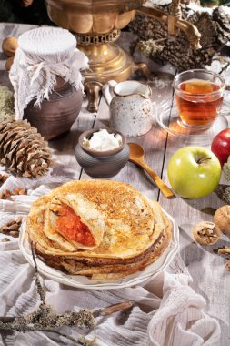 Kumaş arka planda krep, çay, krema ve meyveler