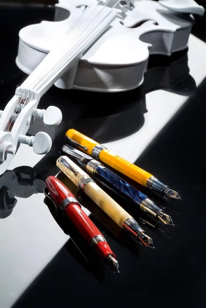 Ручки и скрипка — стоковое фото