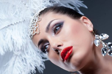 Stüdyo arka planında tüylü şapkası olan güzel bir kadın.