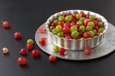 Siyah bir arka plan üzerinde metal bir fırın tepsisine Gooseberries