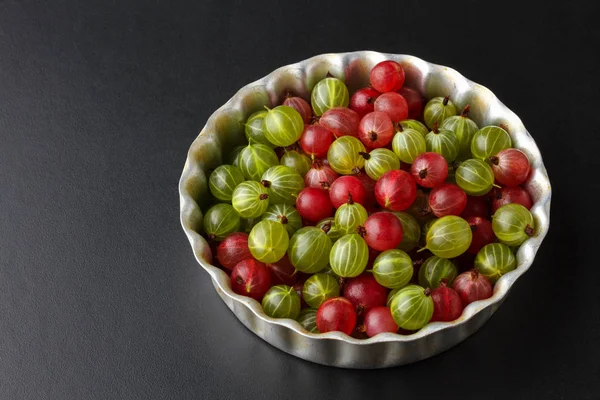 Siyah bir masa üzerinde metal bir fırın tepsisine Gooseberries
