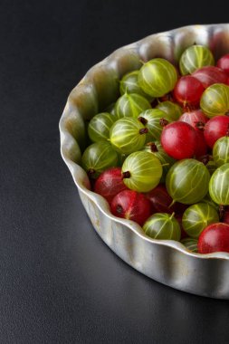 Siyah bir arka plan üzerinde metal bir fırın tepsisine Gooseberries