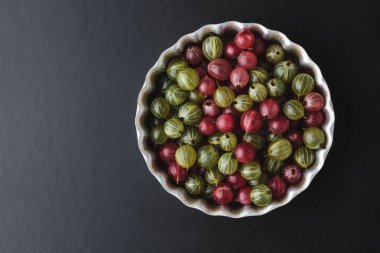 Siyah bir arka plan üzerinde metal bir fırın tepsisine Gooseberries