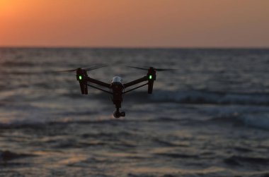 deniz günbatımı arka plan üzerinde quadcopter silüeti