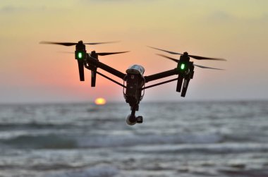 deniz günbatımı arka plan üzerinde quadcopter silüeti