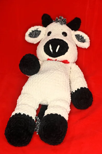 knitted toy Bull symbol of 2021 on the eastern calendar on a red background