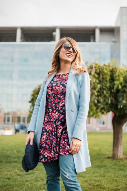 Güneş gözlüğü takıyor ve yaşayan poz çekici genç sarışın kadın