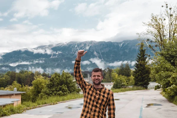 Jovem Sorridente Com Braço Levantado Com Montanhas Fundo — Fotografia de Stock